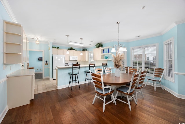 dining space featuring crown molding, a chandelier, and hardwood / wood-style floors