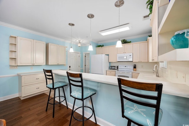 kitchen with white appliances, a kitchen breakfast bar, decorative light fixtures, and kitchen peninsula