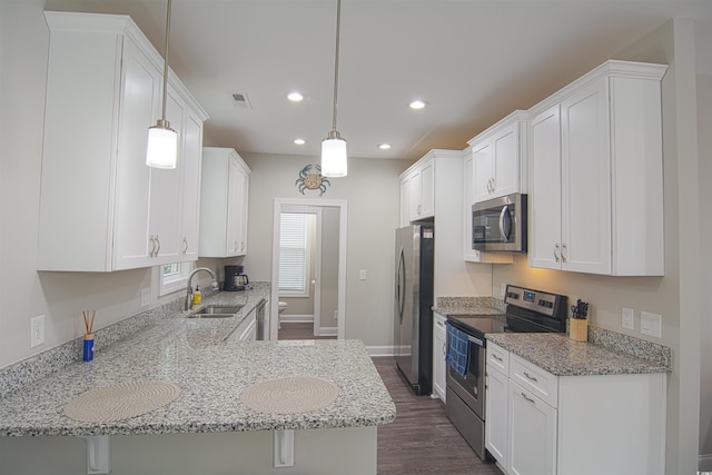 kitchen with sink, stainless steel appliances, kitchen peninsula, and hanging light fixtures