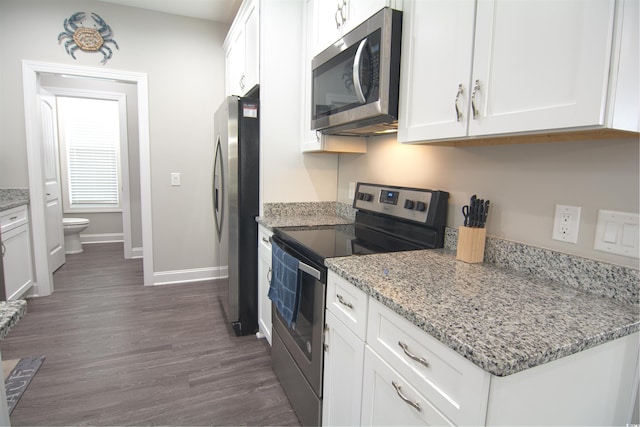 kitchen with light stone counters, stainless steel appliances, dark hardwood / wood-style floors, and white cabinetry