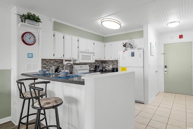 kitchen with white appliances, white cabinetry, crown molding, and kitchen peninsula