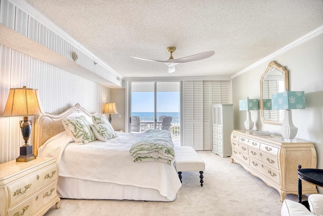 carpeted bedroom featuring a textured ceiling, ceiling fan, crown molding, and access to exterior