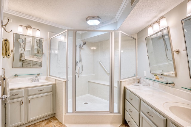 bathroom featuring a textured ceiling, crown molding, tile patterned floors, a shower with shower door, and vanity