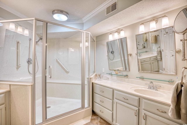 bathroom featuring a textured ceiling, ornamental molding, tile patterned floors, an enclosed shower, and vanity