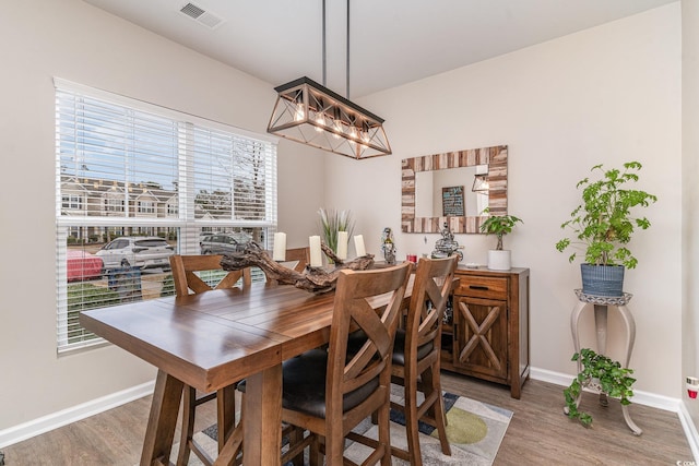 dining room with hardwood / wood-style flooring and an inviting chandelier