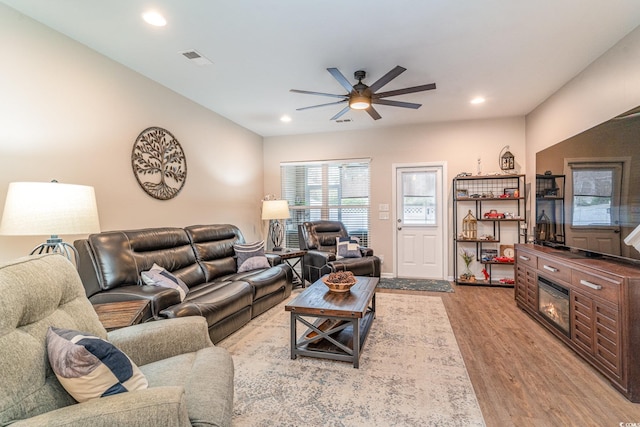 living room with light hardwood / wood-style floors and ceiling fan