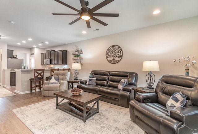 living room featuring ceiling fan and light hardwood / wood-style floors