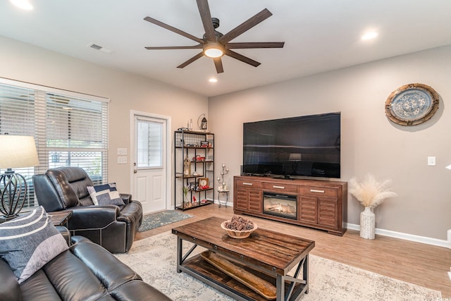 living room with light hardwood / wood-style floors and ceiling fan