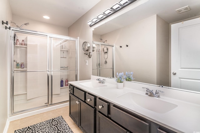 bathroom with an enclosed shower, vanity, and tile patterned floors