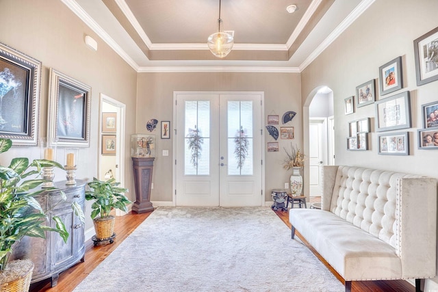 entrance foyer with a raised ceiling, french doors, crown molding, and hardwood / wood-style floors