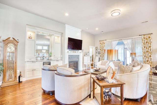 living room featuring a healthy amount of sunlight, wine cooler, and light hardwood / wood-style flooring