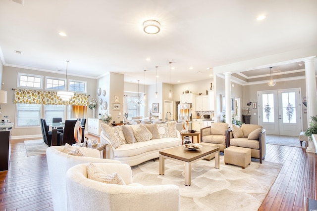 living room featuring french doors, decorative columns, a healthy amount of sunlight, and crown molding