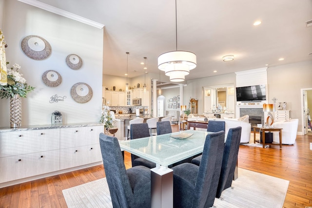 dining space with crown molding and light hardwood / wood-style flooring