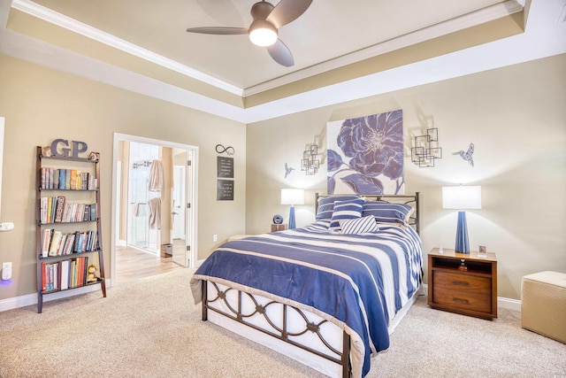 carpeted bedroom with ceiling fan, connected bathroom, crown molding, and a tray ceiling