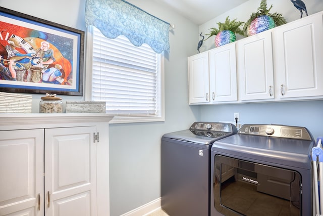 clothes washing area with cabinets and independent washer and dryer