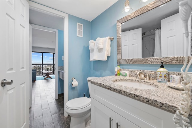 bathroom with a shower with curtain, vanity, and toilet