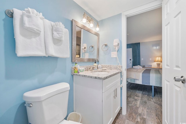 bathroom with wood-type flooring, vanity, and toilet