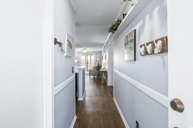 corridor featuring dark wood-type flooring and a textured ceiling