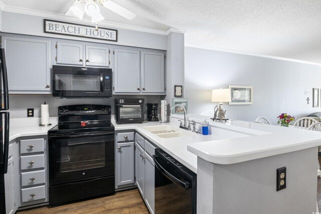 kitchen with sink, a textured ceiling, black appliances, and kitchen peninsula