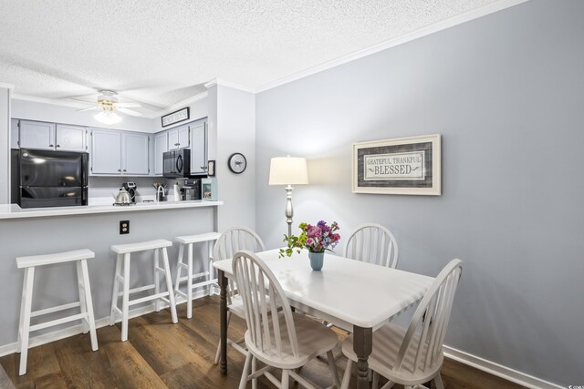 dining room featuring ceiling fan, dark hardwood / wood-style floors, ornamental molding, and a textured ceiling