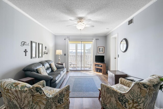 living room with ornamental molding, a textured ceiling, ceiling fan, and hardwood / wood-style floors