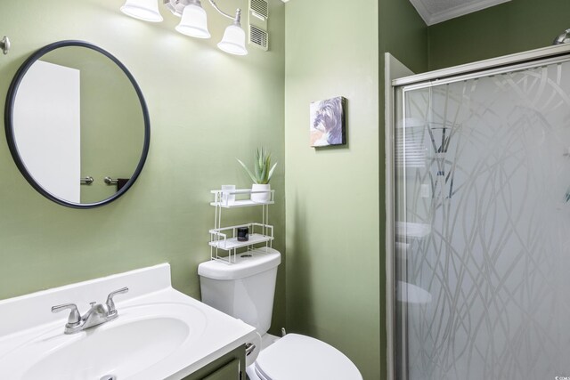 bathroom with ornamental molding, an enclosed shower, vanity, and toilet