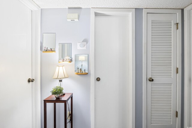 hall featuring a textured ceiling