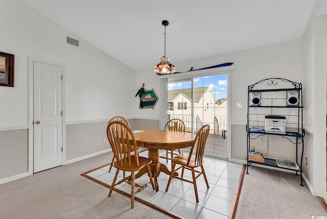 carpeted dining space featuring vaulted ceiling