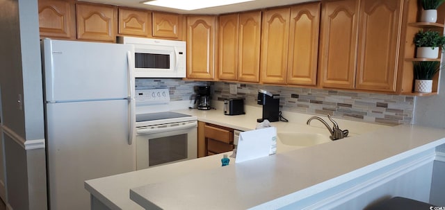 kitchen featuring white appliances, kitchen peninsula, and tasteful backsplash