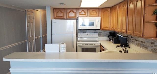 kitchen with white appliances, tasteful backsplash, and sink