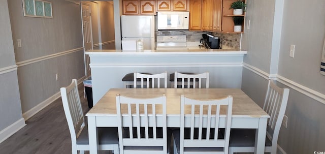 kitchen featuring white appliances, backsplash, and dark hardwood / wood-style floors