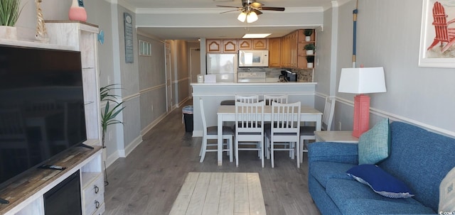 kitchen featuring crown molding, ceiling fan, light hardwood / wood-style flooring, fridge, and tasteful backsplash