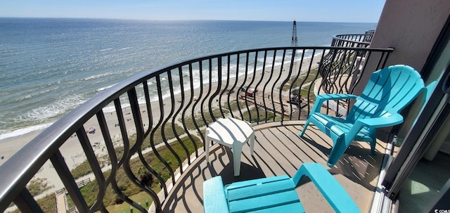 balcony with a water view and a view of the beach