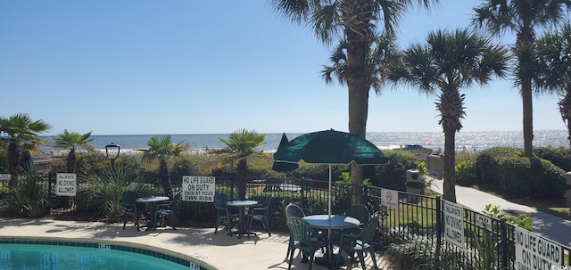 view of pool with a water view and a patio area