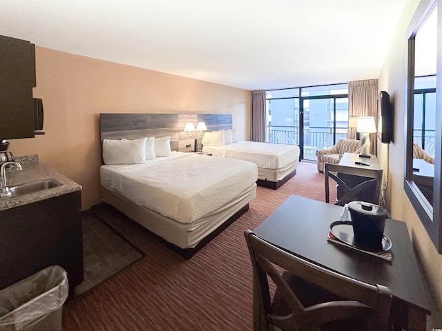 bedroom featuring sink, access to outside, carpet, and expansive windows