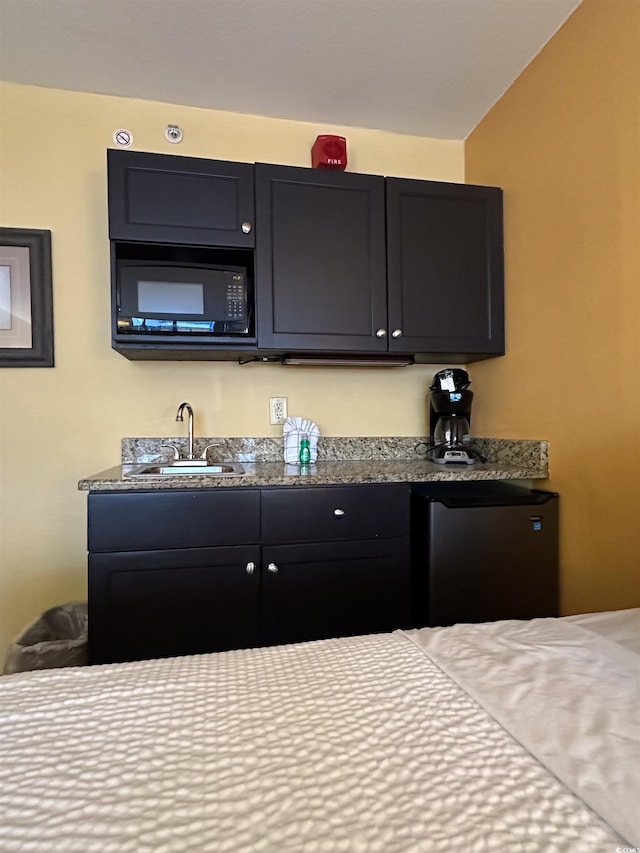 interior space with sink, fridge, and black microwave