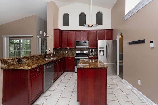 kitchen with light tile patterned floors, high vaulted ceiling, dark brown cabinets, and stainless steel appliances