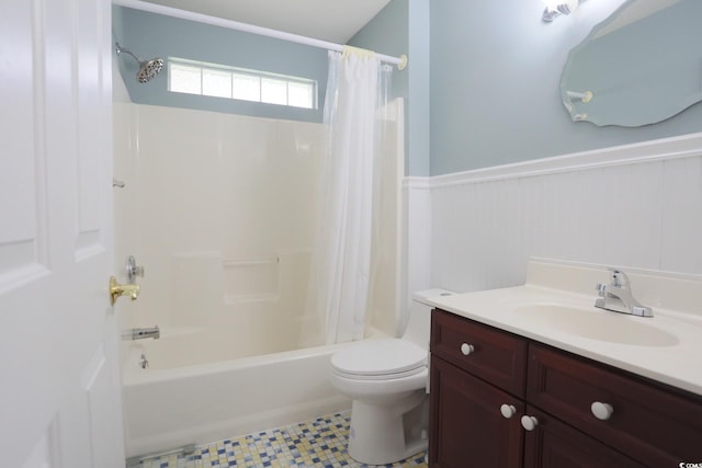 bathroom featuring wainscoting, toilet, vanity, and shower / bath combo