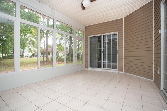 unfurnished sunroom featuring a ceiling fan