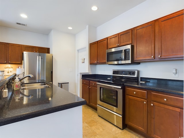 kitchen featuring sink, stainless steel appliances, and dark stone counters