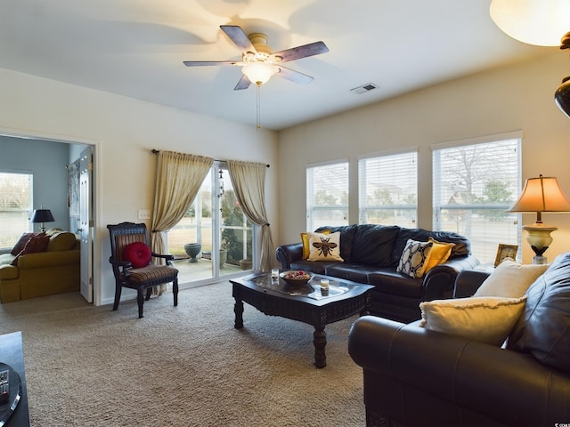 carpeted living room with ceiling fan