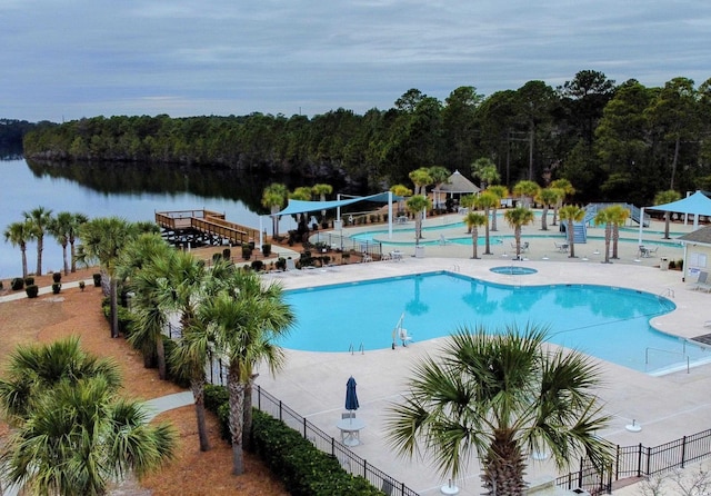 view of swimming pool with a patio area and a water view