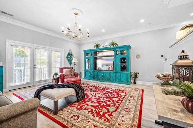 living room with ornamental molding, an inviting chandelier, french doors, and light wood-type flooring