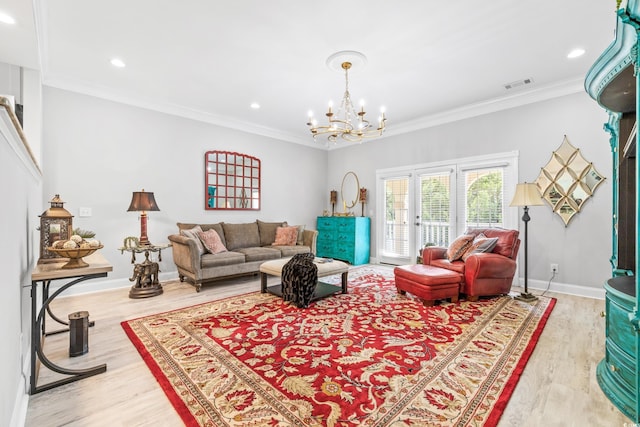 living room featuring hardwood / wood-style flooring, a notable chandelier, and ornamental molding