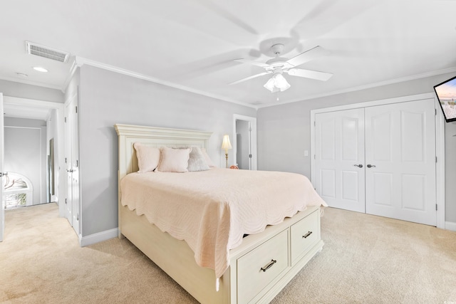 bedroom with ornamental molding, ceiling fan, a closet, and light carpet