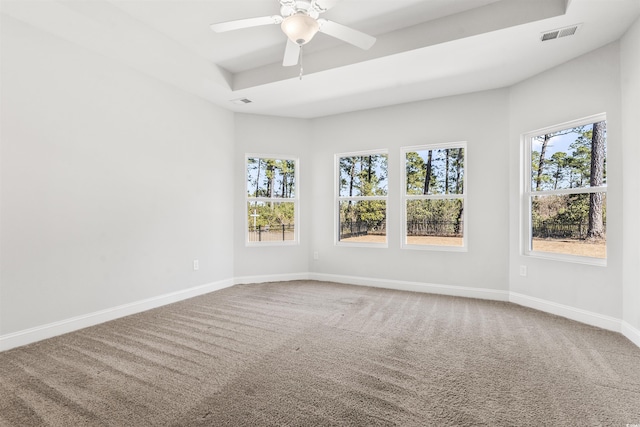 empty room featuring ceiling fan, a wealth of natural light, and carpet floors