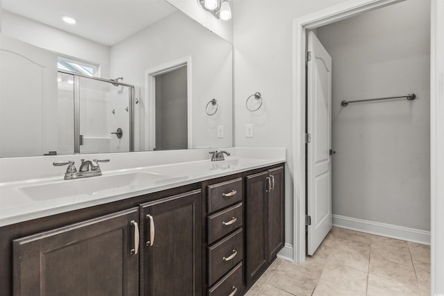 bathroom with a shower with door, tile patterned floors, and vanity