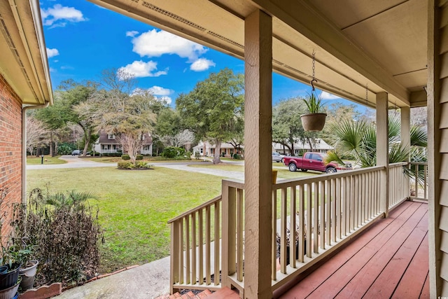 wooden deck featuring a yard and covered porch