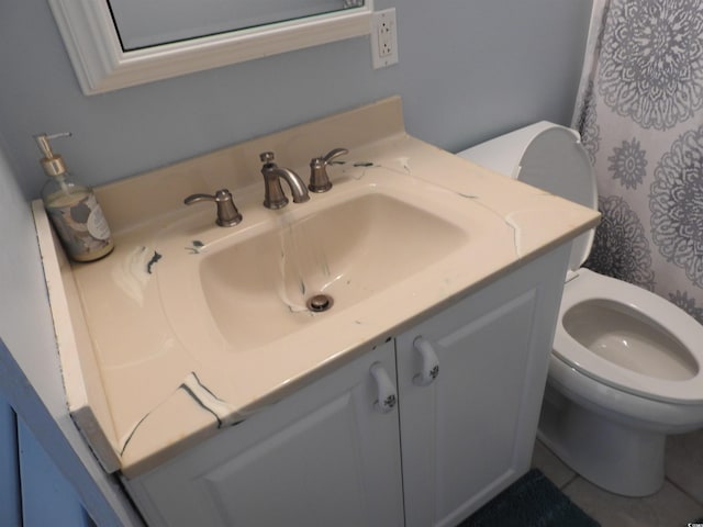 bathroom with toilet, tile patterned floors, and vanity