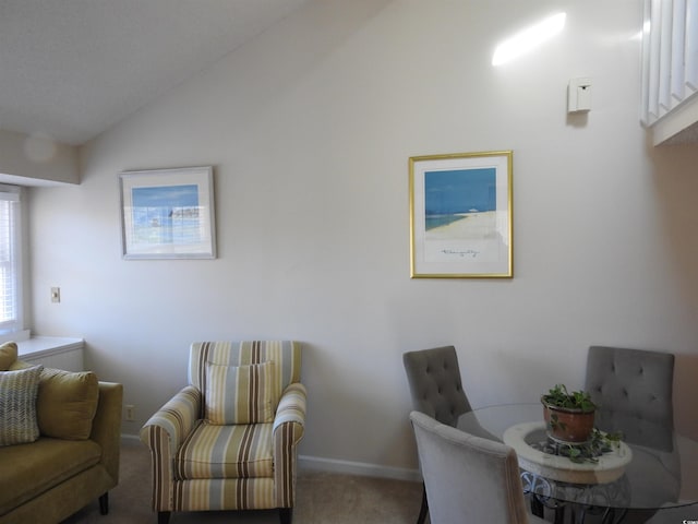 sitting room featuring carpet flooring and vaulted ceiling